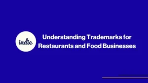 Blue presentation slide with white text: “Understanding Trademarks for Restaurants and Food Businesses.” On the left, a white circle with the word “indie” in lowercase script. Thin yellow and white lines at the bottom right.