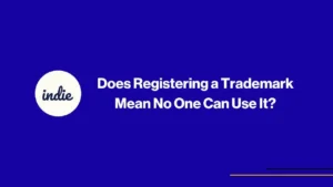 A blue background with a white circle containing the word indie on the left, and the text “Does Registering a Trademark Mean No One Can Use It?” in bold white letters centered on the right.