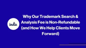 Image with a blue background features the indie logo on the left. The text reads: “Why Our Trademark Search & Analysis Fee is Non-Refundable (and How We Help Clients Move Forward).” Thin yellow lines appear in the lower right corner.