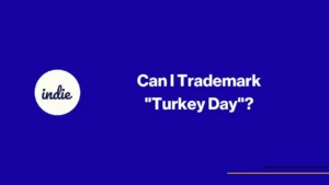 Blue slide with the indie logo on the left and the white text Can I Trademark Turkey Day? on the right. Thin yellow and purple lines are at the bottom right corner.