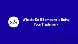 Blue background with a white circle on the left containing the word indie. Centered white text reads What to Do If Someone Is Using Your Trademark. Thin yellow and purple lines in bottom right corner.