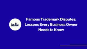 A blue background with a white circle on the left containing the word indie and bold white text reading: Famous Trademark Disputes: Lessons Every Business Owner Needs to Know. Thin yellow lines are at the bottom right.