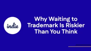 Dark blue background with a white circle containing the word indie on the left. Large white text on the right reads, Why Waiting to Trademark Is Riskier Than You Think.” Thin yellow line underneath.
