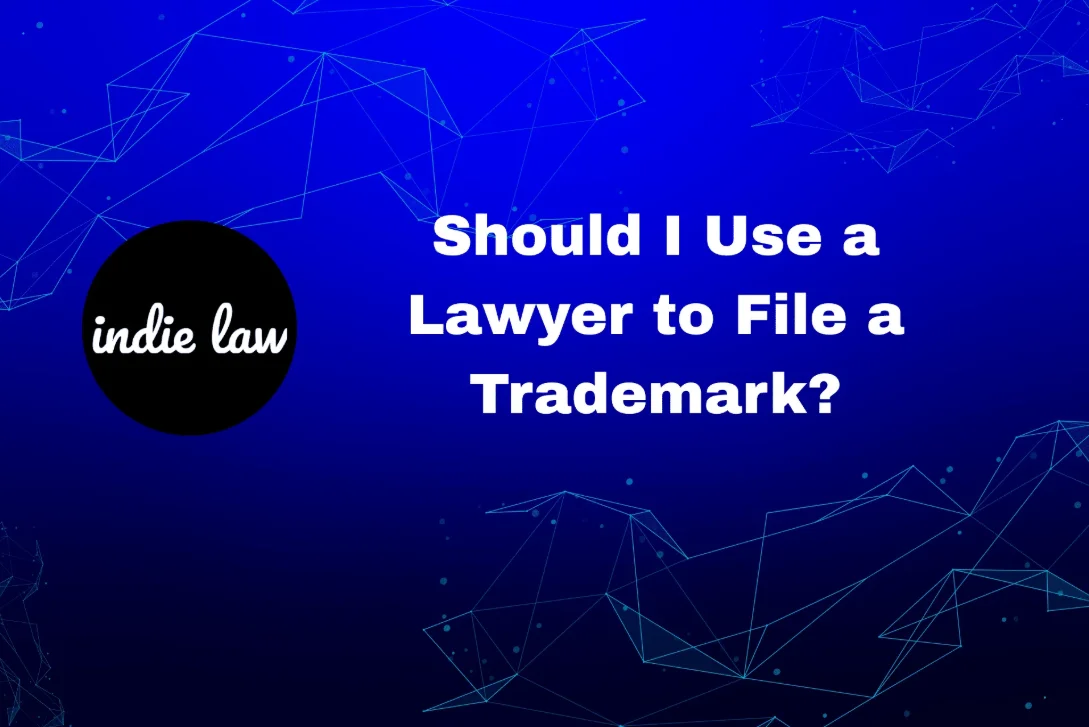 A graphic with the text “Should I Use a Lawyer to File a Trademark?” and the indie law logo on a blue background with abstract line designs.