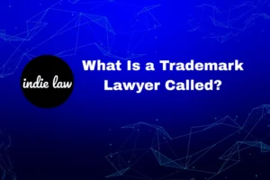 Blue graphic with geometric lines, "indie law" logo on the left, and the text "What Is a Trademark Lawyer Called?" on the right.