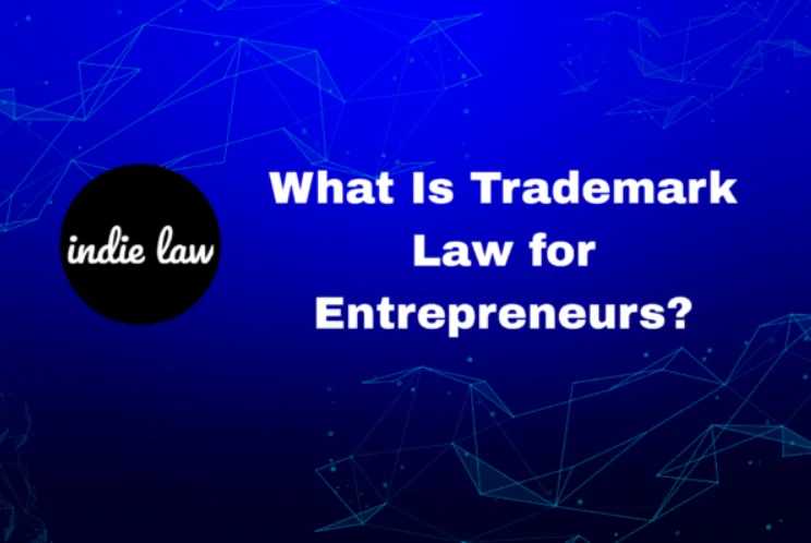 A digital graphic with a blue abstract background features the text "What Is Trademark Law for Entrepreneurs?" alongside a black circle labeled "indie law" on the left, highlighting essential trademark law insights.