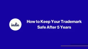 Blue background with a white circle on the left containing the word indie. To the right, bold white text reads: How to Keep Your Trademark Safe After 5 Years. Thin yellow lines are at the bottom right corner.
