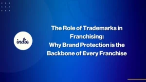 Blue background with white text that reads, The Role of Trademarks in Franchising: Why Brand Protection is the Backbone of Every Franchise. A circle with indie written inside is on the left.