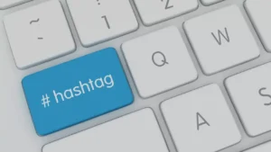 A computer keyboard with a blue key labeled “#hashtag” replacing the usual Enter key, surrounded by white keys.