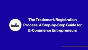 Blue background with white text that reads, The Trademark Registration Process: A Step-by-Step Guide for E-Commerce Entrepreneurs, and a white circle with indie written in cursive. Thin yellow and blue lines are at the bottom right.